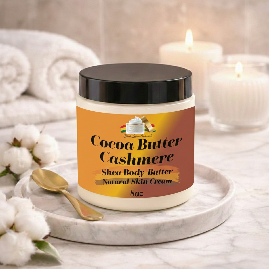 Jar of Cocoa Butter Cashmere shea body butter on a marble surface with cotton and candles in the background.