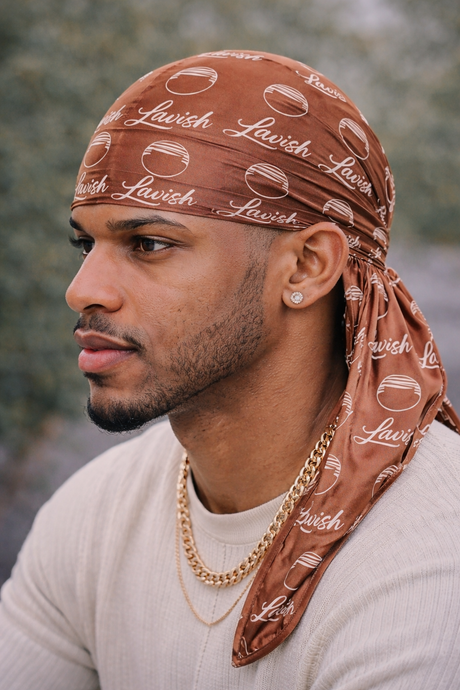 Man wearing a brown bandana with 'Lavish' text and a gold chain necklace.